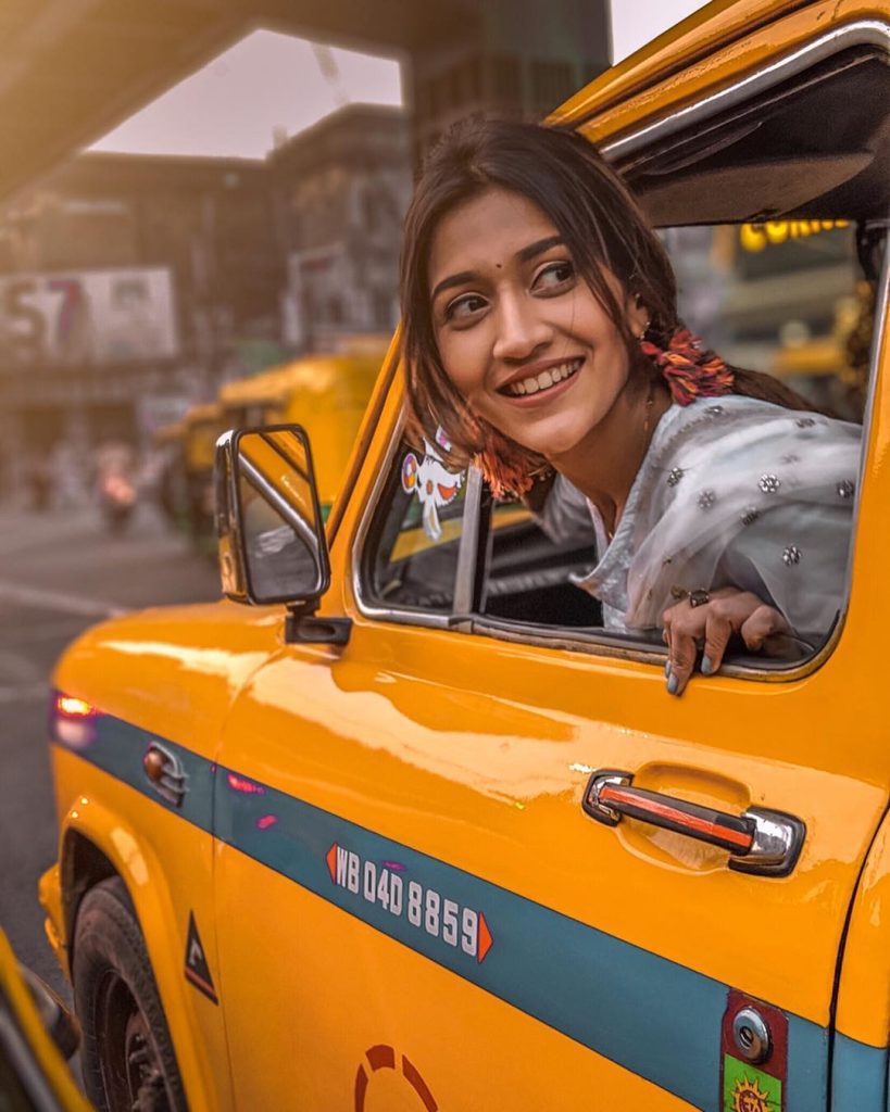 A cheerful lady in a Kolkata Iconic Yellow Taxis ride